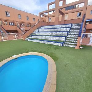an empty swimming pool in front of a building at Casa M de mar - Vistas 180º in Corralejo