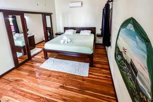 a room with a bed and a mirror at Hona Beach Hotel in Dominical