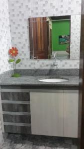 Un mostrador de baño con un lavabo y un espejo. en Chacara Santa Barbara, en Manaus