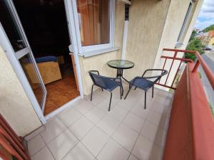 einen Balkon mit 2 Stühlen und einem Tisch auf einer Veranda in der Unterkunft Epreskert Apartman in Nyíregyháza