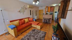 a living room with a couch and a kitchen at Epreskert Apartman in Nyíregyháza