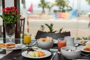 una mesa cubierta con platos de comida y bebida en Hotel Praia Bonita Pajuçara, en Maceió
