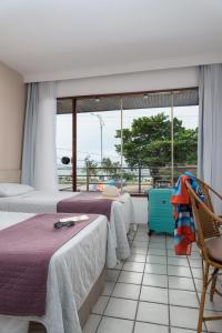 2 camas en una habitación con ventana grande en Hotel Praia Bonita Pajuçara, en Maceió