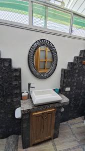 a bathroom with a sink and a mirror at Alpha House in Vilcabamba