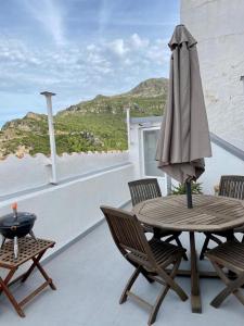 un patio con mesa y sombrilla en La casita de Lú, en Casares