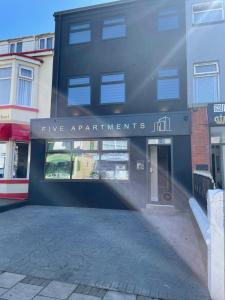 un bâtiment noir avec un panneau indiquant cinq appartements dans l'établissement Five Apartments, à Blackpool