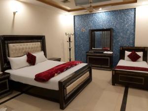 1 dormitorio con 2 camas y espejo en Hotel Visit Inn One, en Lahore