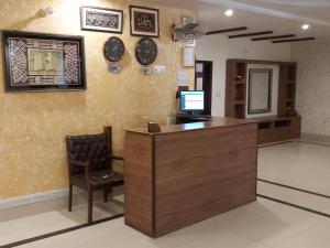 a lobby with a desk with a computer and a chair at Hotel Visit Inn One in Lahore