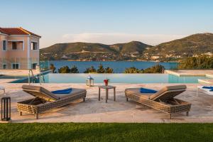 un patio con 2 sillones y una mesa en Danae Luxury Apartment en Samos