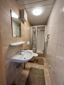 een badkamer met een wastafel, een toilet en een spiegel bij Haus Barbara in Waidring
