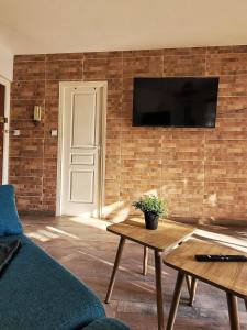 un salon avec une télévision sur un mur en briques dans l'établissement Parking privé + Jardin + Clim proche Plage & Resto, à Cagnes-sur-Mer