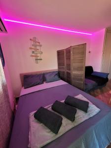 sypialnia z łóżkiem z różowym oświetleniem w obiekcie Parking privé + Jardin + Clim proche Plage & Resto w Cagnes-sur-Mer