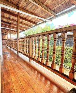 balcón de una casa con barandilla de madera en HOSTAL EL COLIBRI, en Puyo