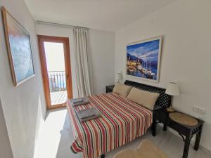 a small bedroom with a bed and a window at Spacious seafront apartment in Platja d'Aro