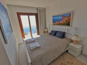 a bedroom with a bed with a painting on the wall at Spacious seafront apartment in Platja d'Aro +11 photos
