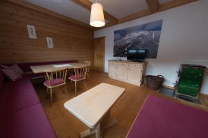 een kamer met 2 tafels en stoelen en een tv bij Haus Barbara in Waidring