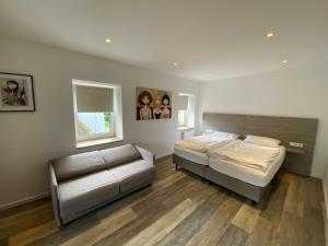 a bedroom with a bed and a couch at Eschberger Hof in Saarbrücken