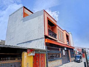 a tall building with an orange and gray at OYO 91649 Orange Homestay Makassar in Makassar