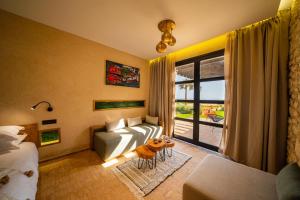 a hotel room with a couch and a window at BABERRIH Hôtel Hospitality Palaces & Resorts in Essaouira