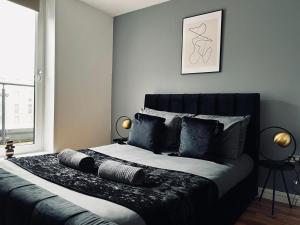 a bedroom with a large bed with black pillows at 2 Bedroom Penthouse Birmingham in Birmingham