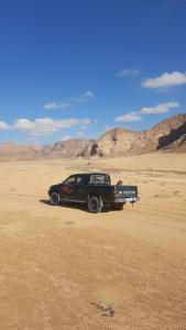 un camión negro estacionado en el desierto en Atef camp en Wadi Rum