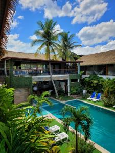 una imagen de un complejo con piscina y palmeras en Las Hamacas Hotel, en Sauce