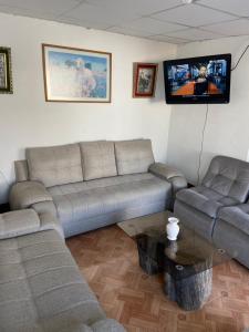 sala de estar con 2 sofás y TV de pantalla plana en Caraz Dulce Hogar, en Caraz