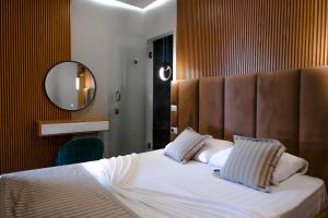 a bedroom with a large bed with a large mirror at Luna Mare Boutique Seaside in Borsh