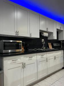 cocina con armarios blancos y microondas en Amazing 1bd apartment with big office, en Los Ángeles