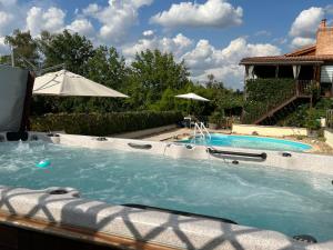 una piscina en un patio con sombrilla en Lake Noble en Saint-Germain-lʼAiguiller
