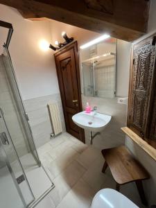 ein Badezimmer mit einem Waschbecken, einem WC und einem Spiegel in der Unterkunft Chalet Blanc "La Mansarda" in Courmayeur
