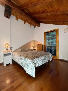 1 dormitorio con 1 cama y suelo de madera en Chalet Blanc "La Mansarda" en Courmayeur