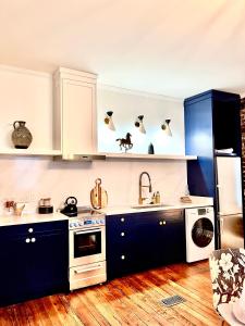 a kitchen with white cabinets and blue counters at Be Our Gaston's "The Garden of Good" in Savannah