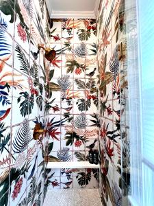een betegelde muur in een badkamer met bloemenbehang bij Be Our Gaston's "The Garden of Good" in Savannah