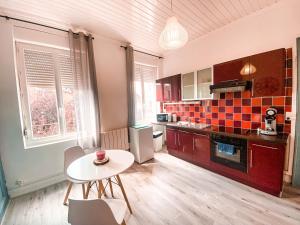 uma cozinha com uma mesa e uma pequena mesa e cadeiras em * The Gold Time * Appartement confort * Centre-Ville em Calais
