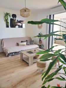 uma sala de estar com um sofá e uma mesa em Appartement T2 sur Mauguio avec grande terrasse em Mauguio