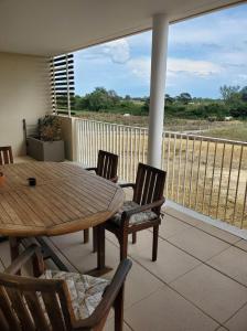 モーギオにあるAppartement T2 sur Mauguio avec grande terrasseのポーチ(木製テーブル、椅子付)