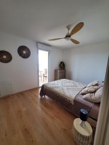 a bedroom with a bed and a ceiling fan at Appartement T2 sur Mauguio avec grande terrasse in Mauguio