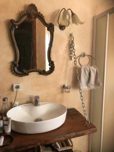 a bathroom with a white sink and a mirror at Archontiko Stafylopati in Makrinítsa