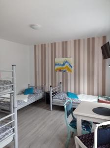 Zimmer mit 3 Etagenbetten und einem Tisch in der Unterkunft Dom Mili in Henryków Lubański