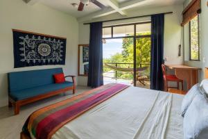 a bedroom with a bed and a couch and a window at Casa Paraíso - 2nd Floor in San Juan del Sur