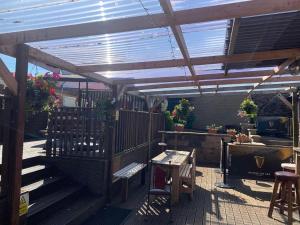 a patio with a wooden pergola and a table and chairs at Cutty Sark Inn in Eyemouth