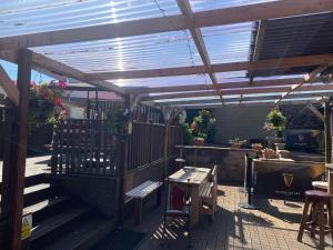 un patio con pérgola de madera, mesa y sillas en Cutty Sark Inn en Eyemouth