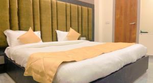 1 dormitorio con 1 cama grande con almohadas blancas en City View With Garden -5 Mins Walk From GOLDEN TEMPLE en Amritsar
