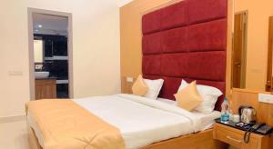 um quarto com uma cama grande e uma cabeceira vermelha em City View With Garden -5 Mins Walk From GOLDEN TEMPLE em Amritsar
