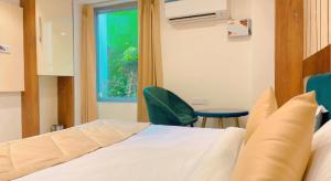 a bedroom with a bed and a chair and a window at City View With Garden -5 Mins Walk From GOLDEN TEMPLE in Amritsar