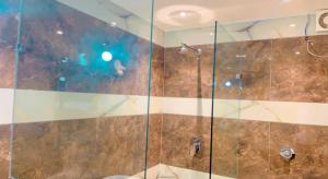 una doccia con porta in vetro in bagno di City View With Garden -5 Mins Walk From GOLDEN TEMPLE ad Amritsar