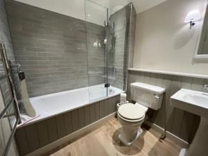 a bathroom with a toilet and a shower and a sink at Walcot Yard, Bath in Bath