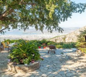 a patio with a table and chairs and plants at Archontiko Stafylopati in Makrinitsa