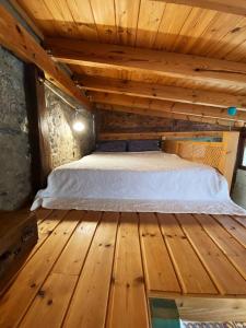 a bed in a room with a wooden floor at La Casita Azul in Caleta de Interián